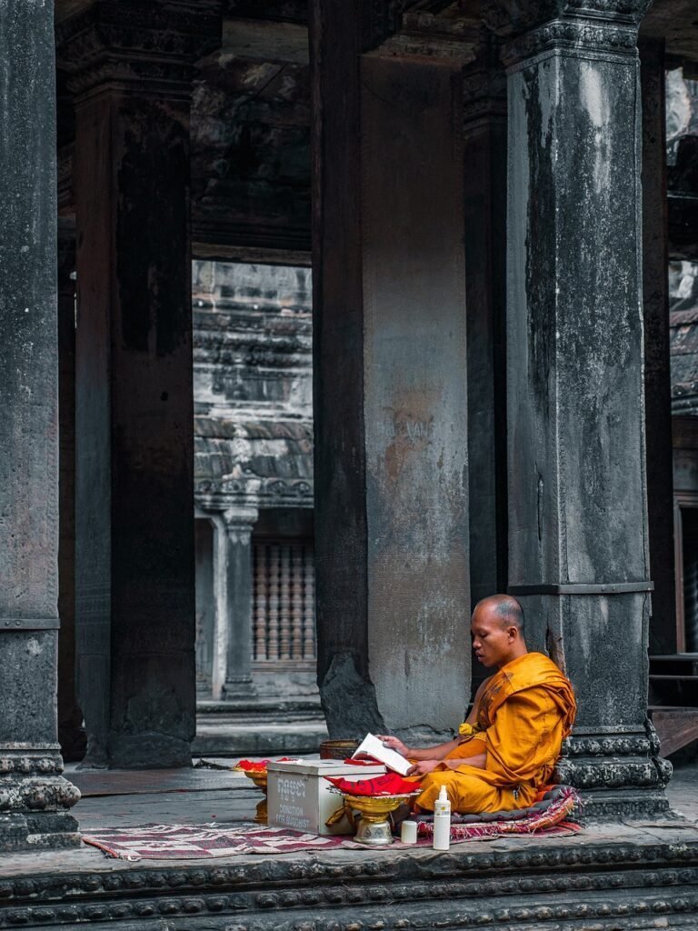 a monk/spiritual coach sitting cross legged, reading a book