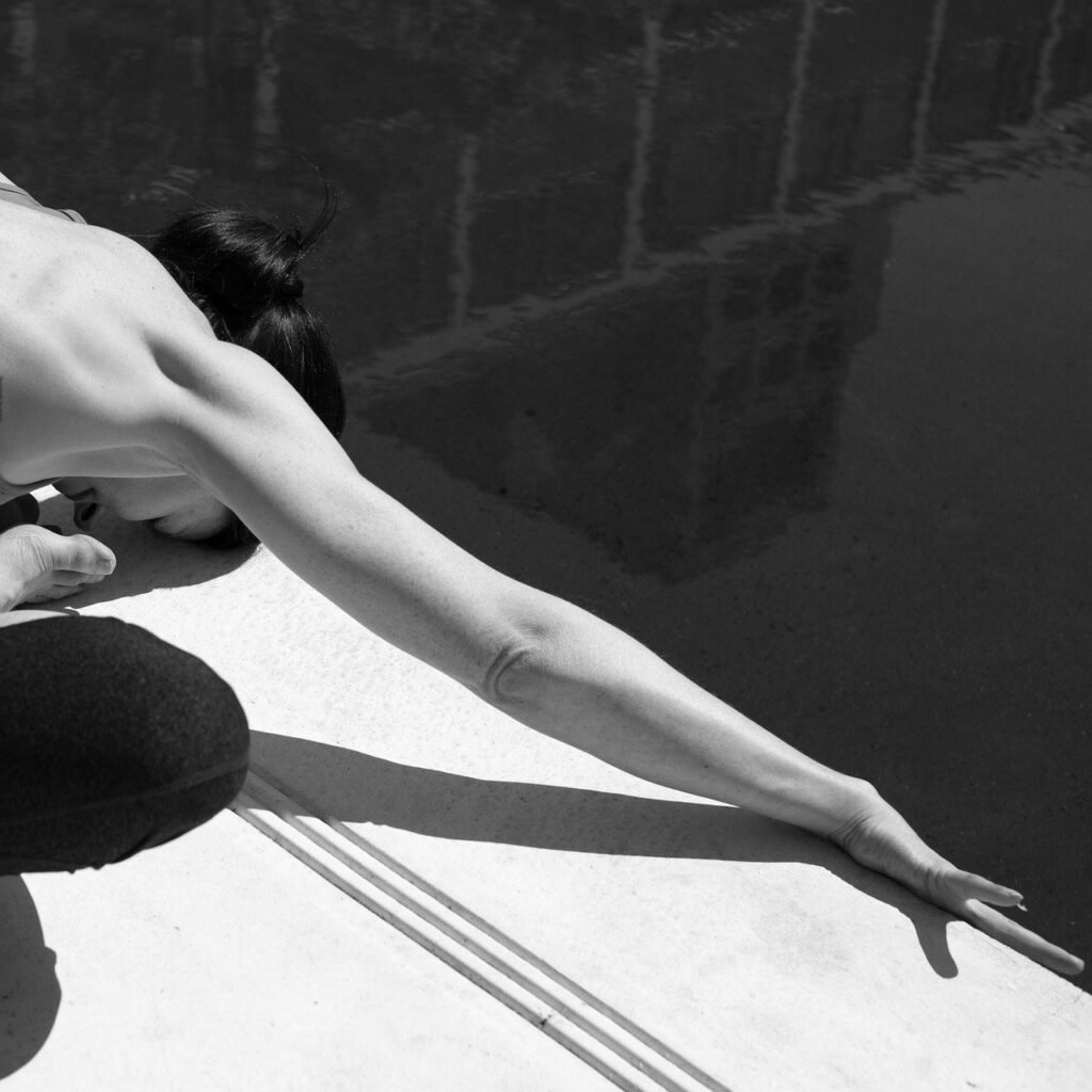a lady stretching forward showing one of the positions in one of our yoga classes